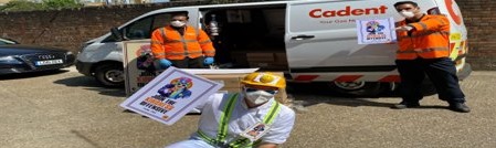 Three workers in protective gear and masks hold appreciation posters, standing near a Cadent-branded van under a clear sky, conveying gratitude and teamwork.