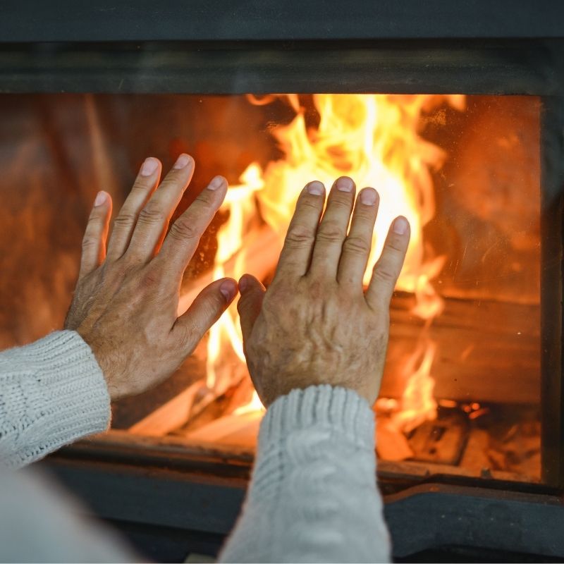 Person heating his hands in front of fire