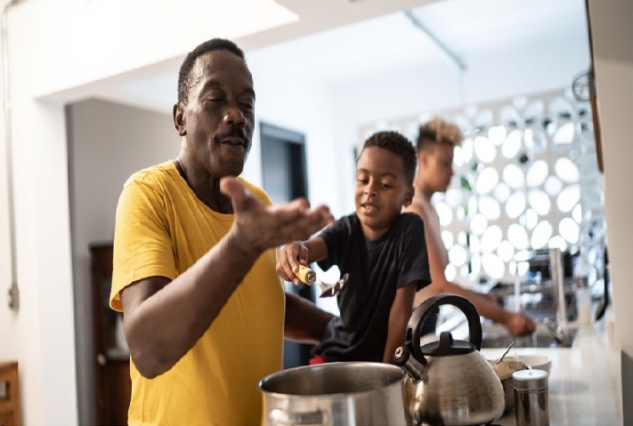 Three people including a child in a modern kitchen setting