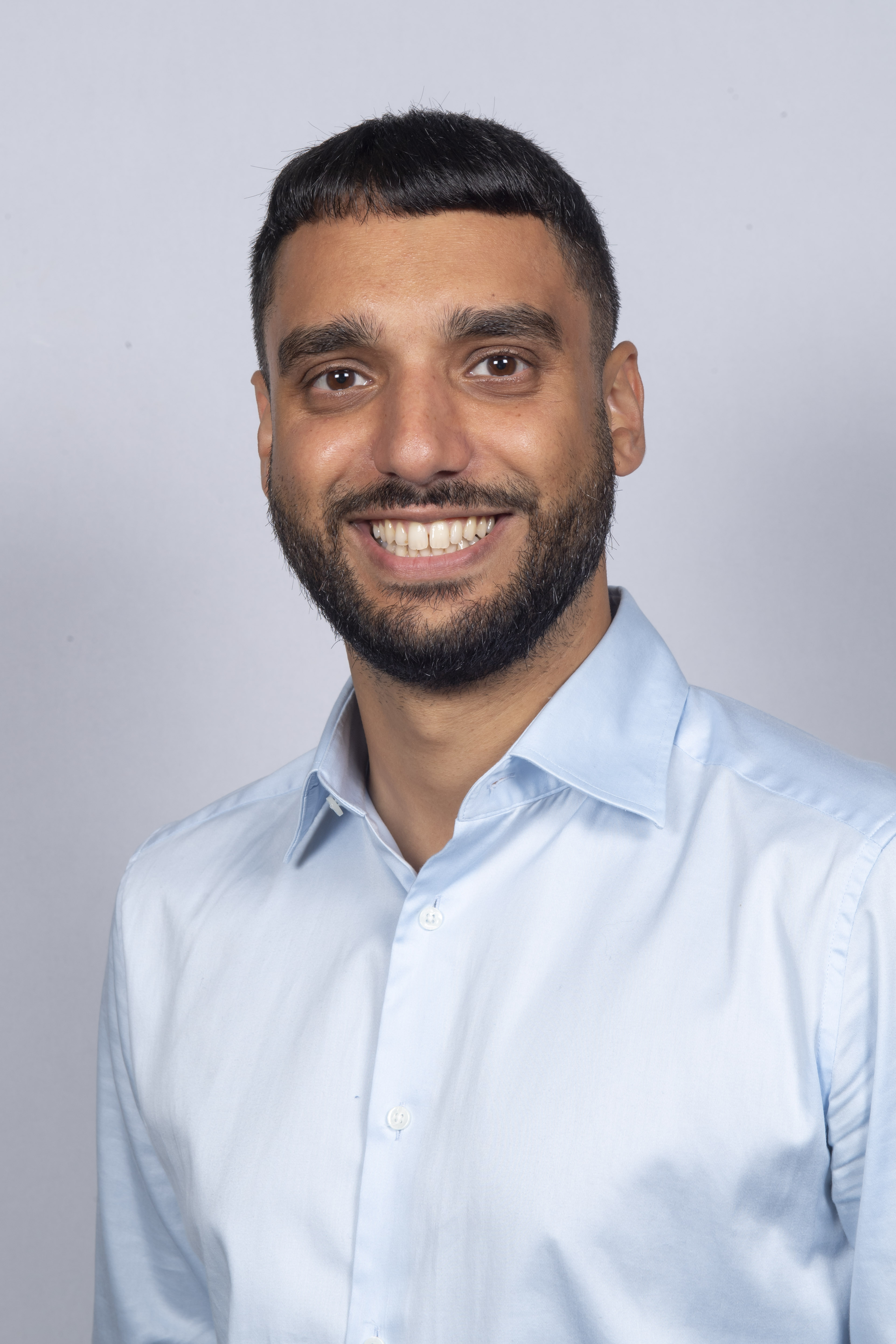a headshot of person smiling and standing.