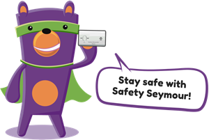 A friendly purple bear character, Safety Seymour, wearing a green mask and cape, promotes safety while holding a card and smiling.